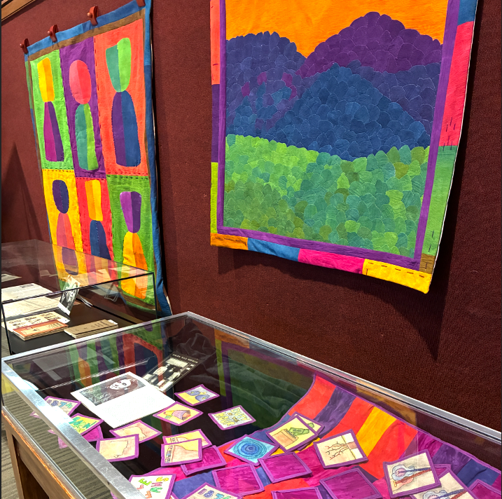  Dr. Jaleesa Wells - Class is in Session and Mountains are Calling (wall hanging quilts over display case with smaller quilted patches)