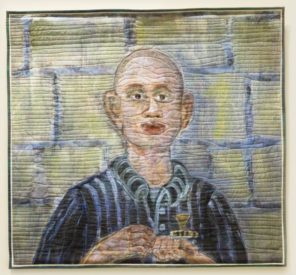 Colleen Ansbaugh - Szajna (quilted portrait of a bald man in a striped shirt in front of a brick wall)