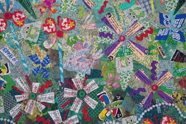 Pat Kroth - Plays The Thing (detail of an art quilt made from found objects and trash including beanie baby tags shaped into flowers)