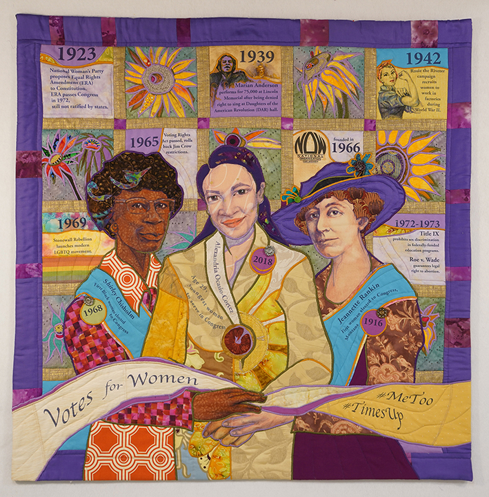 Artwork by Ellen M. Blalock (a quilted portrait of Shirley Chisholm, Alexandria Ocasio Cortez, and Jeannette Rankin hold a banner that says "votes for women #metoo #timesup")