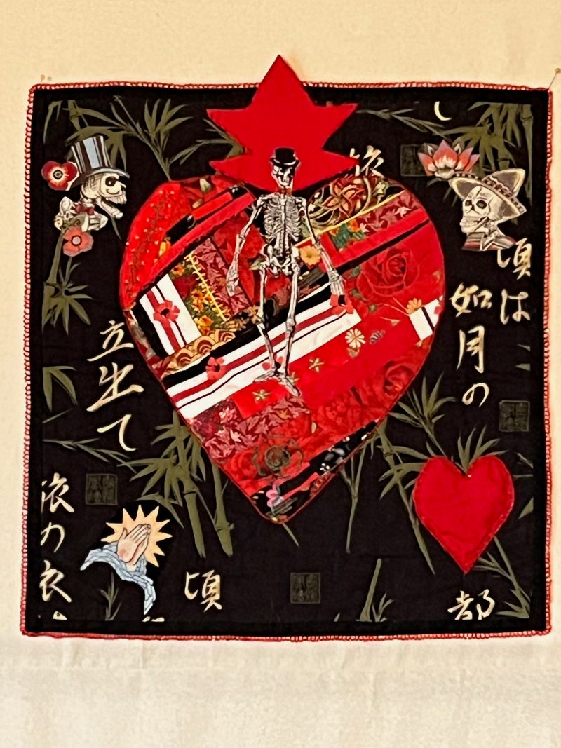 Gaby Litsky - Heart of a Skeleton (skeletons in hats appliqued on a heart and black background)