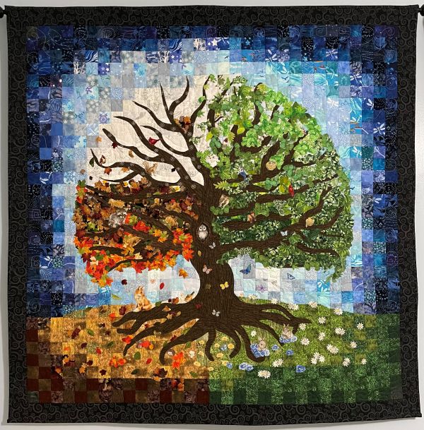 Emma Allen - A Tree for All Seasons (a quilt depicting a tree going through all four seasons. The with a background of squares creates a vignette around the tree, going from light at the center to a black border)