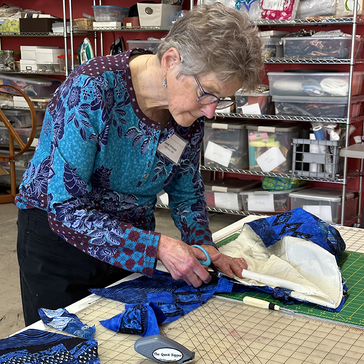 A woman working on artwork at the Schweinfurth fiber retreat