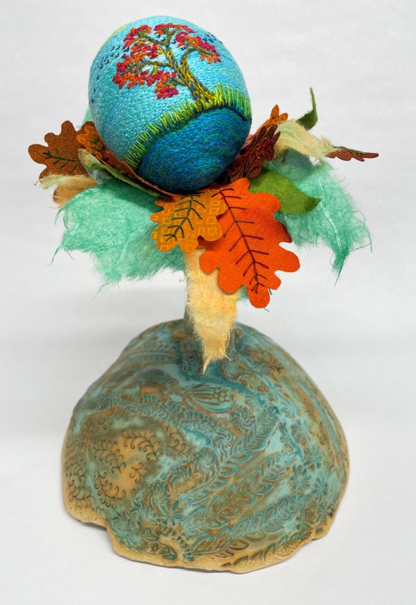Laura Wasilowski - Tree in Autumn (a sculpted tree on a ceramic base. Some of the leaves are made of felt. An embroidered egg perches on top with a tree stitched on it)