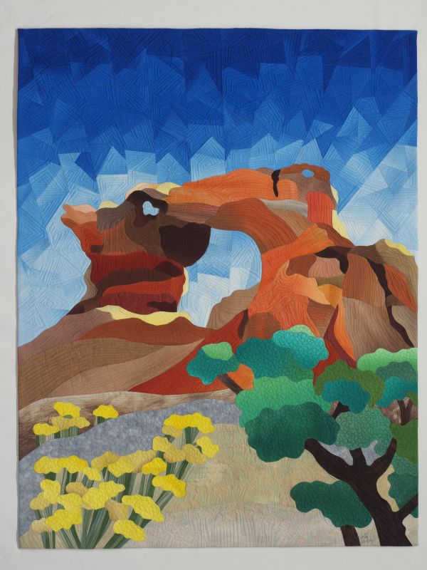 Vicki Conley - Aztec Arch (a landscape quilt with a red rock arch against a fragmented blue sky)