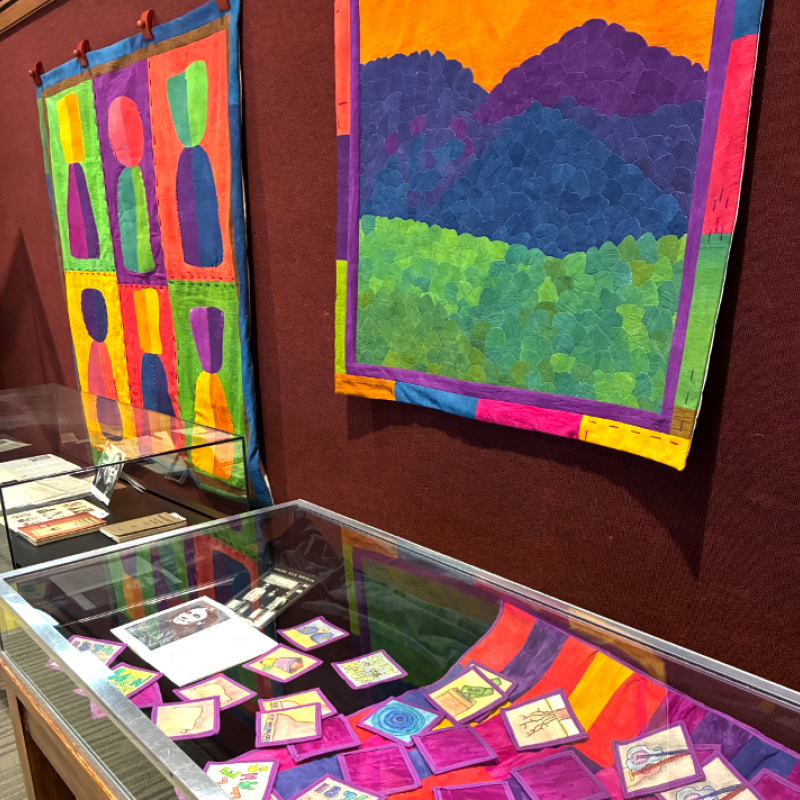  Dr. Jaleesa Wells - Class is in Session and Mountains are Calling (wall hanging quilts over display case with smaller quilted patches)