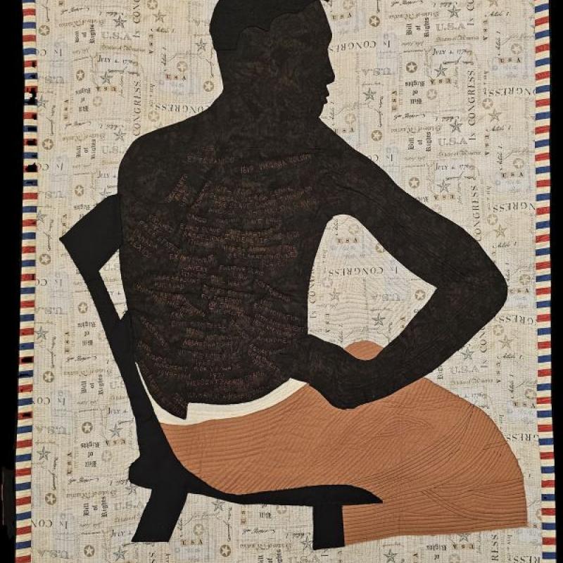 Deborah A Moore Harris - Peter aka Gordon: Retrospective (a quilt of a shirtless man's silhouette in a chair. there is writing on his back)