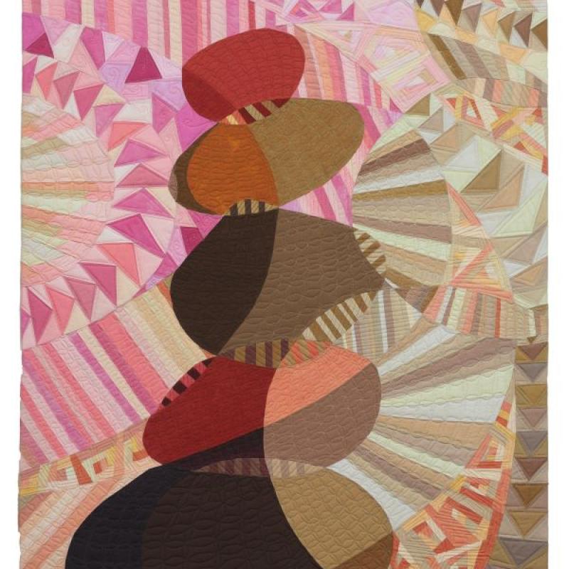 Vicki Conley - Rock Cairn #2 (quilt showing a rock cairn on a background of pink and tan triangles and stripes)