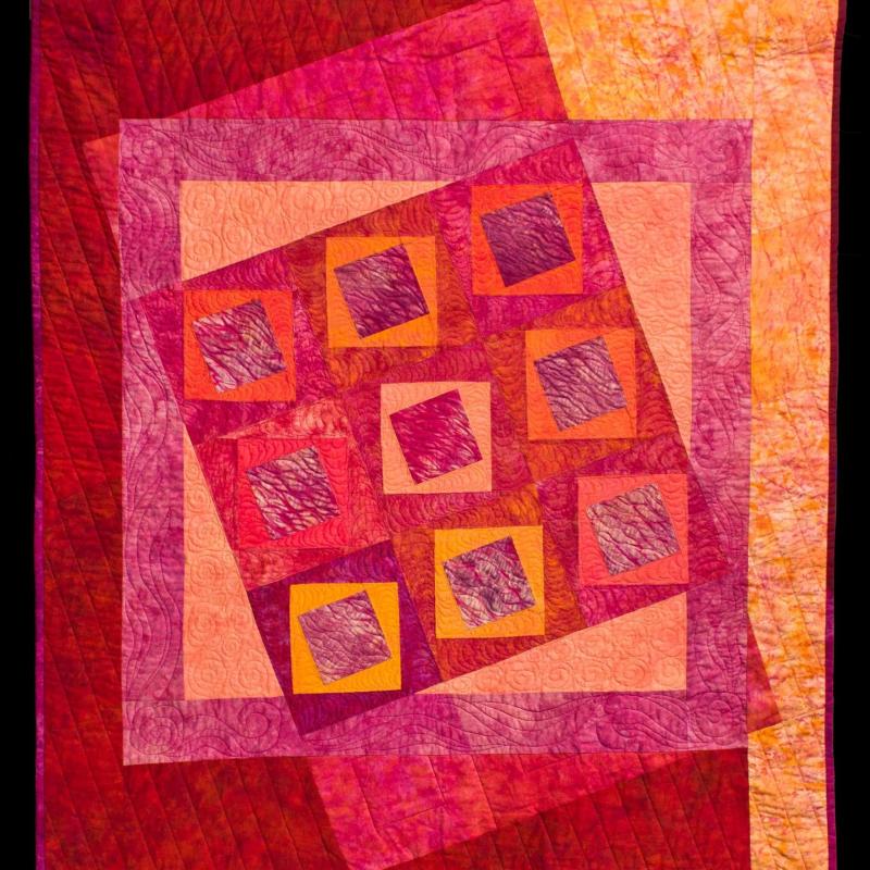 Kindy Kemp - The East Is Red (a quilt with red and orange background and red and orange squares)